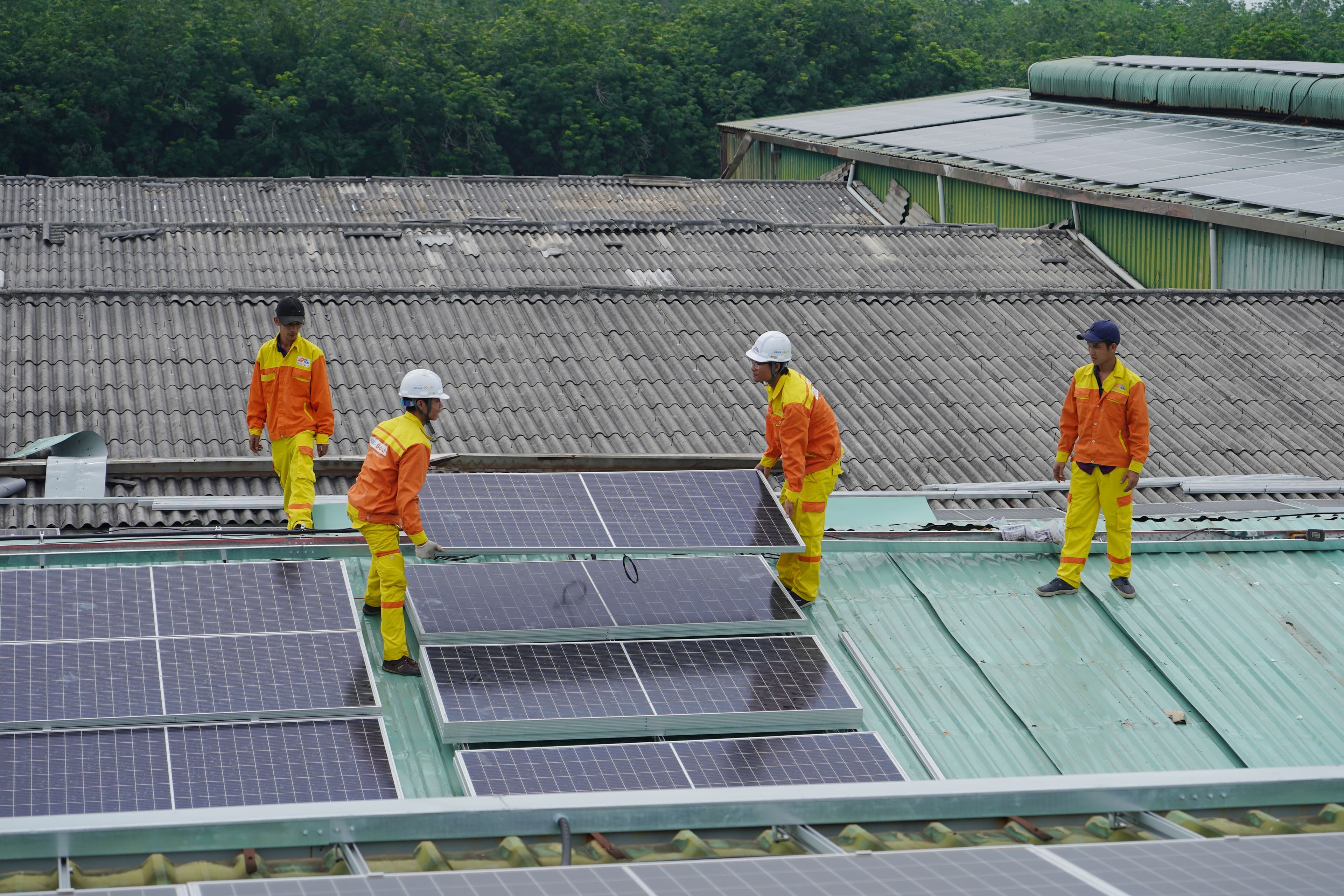 Workers installing solar panels on a rooftop